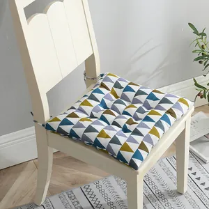 Detalle de un cojín de silla cuadrado y grueso con un colorido patrón geométrico de triángulos.