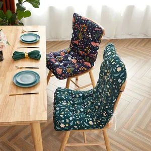 Macro view of integrated floral pattern chair cushions on wooden dining chairs set