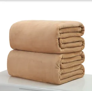 Soft beige flannel fleece blankets folded neatly on a white surface for a cozy home feel