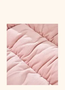 Macro detail showing the exquisite quilting texture of a pink plush heated seat cushion
