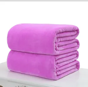 Close-up of soft magenta flannel fleece blankets folded on a white surface