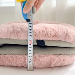 Detailed macro view of a pink plush heated seat cushion showing 20cm thickness measurement.