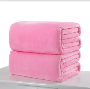 Detail view of two neatly stacked soft pink flannel fleece blankets on a white surface
