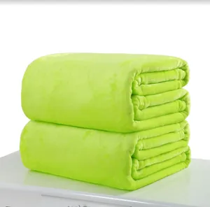 Soft lime green flannel blanket stacked on a white surface for cozy home comfort.
