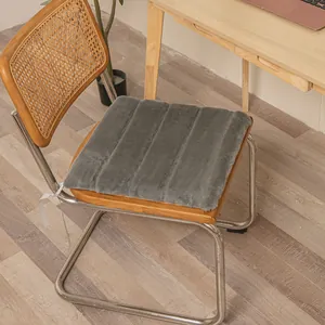 Detailed view of a soft gray faux fur chair cushion with elegant vertical stripes.