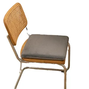 Comfortable soft grey plush square seat cushion pad on a retro wooden rattan chair