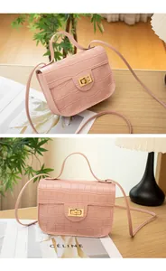 Detailopname van een roze crossbodytas met krokodillenpatroon op een houten tafel.