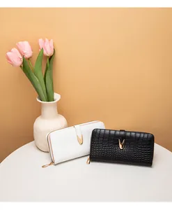 Detalle de carteras largas para mujer con patrón de piedra en blanco y negro y cierre dorado
