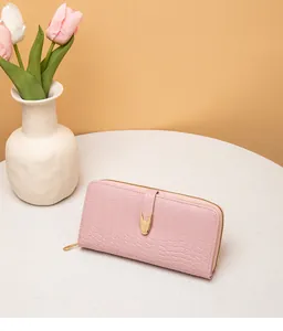 Detalle macro de elegante cartera larga para mujer rosa con textura de piedra y herrajes dorados