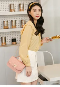 Elegant pink quilted PU leather chain crossbody bag styled with Asian model in cafe
