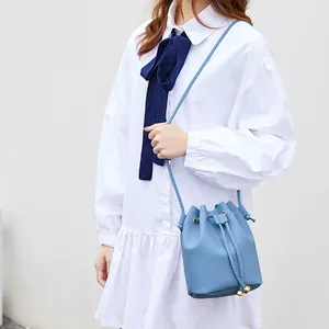 Minimalist blue lychee pattern drawstring bucket bag for women shown as crossbody bag