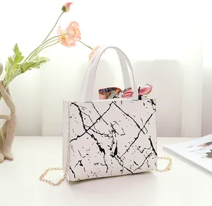 Stylish white square handbag with black marble print and colorful silk scarf handle detail