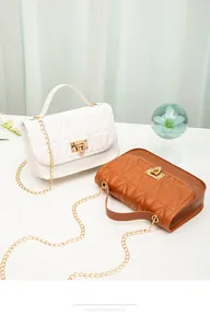 Close-up detail of white and brown quilted PU chain bags with elegant gold latches