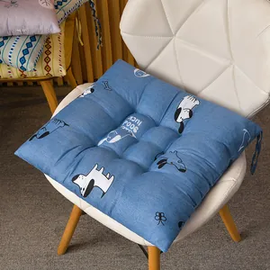 Vista detallada de un cojín de silla cuadrado azul con estampado de perro en silla blanca