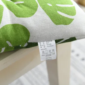 Primer plano de un cojín cuadrado grueso con estampado de hojas verdes