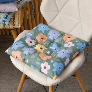 Vista detallada del cojín de silla cuadrado con estampado floral en silla blanca