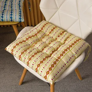 Cómodo cojín para asiento con patrón geométrico en una silla blanca moderna.
