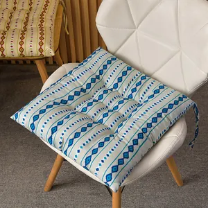 Detalle de cojín para silla cuadrado con patrón geométrico azul bohemio en una silla