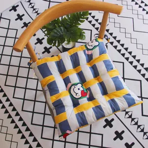 Vista superior de un cojín de silla a rayas azules y amarillas con estampado de oso