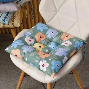 Vista detallada de un cojín de asiento cuadrado con estampado floral sobre una silla blanca moderna