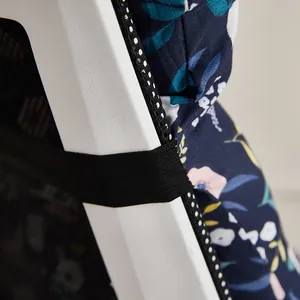 Detailed macro shot of floral navy chair cushion showing the black elastic securing strap