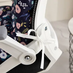Detail of white ribbon tie securing a floral one-piece office chair cushion to frame