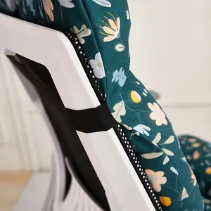 Close-up of floral chair cushion showing the black elastic fixing strap on a white chair