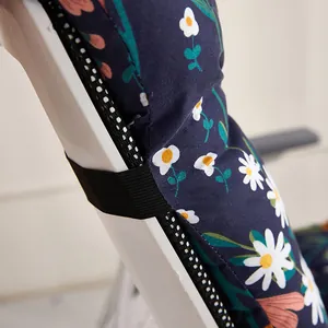 Close-up detail of integrated chair cushion showing secure elastic strap and daisy floral pattern