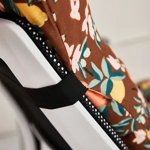 Macro detail of brown floral chair cushion showing elastic strap and mesh border trim
