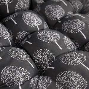 Detailed view of thick padded chair seat cushion featuring white tree pattern prints