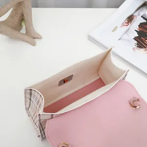 High-angle interior view of stylish color-block plaid crossbody bag with soft pink flap