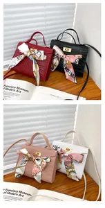 Primo piano di borse con motivo a coccodrillo con foulard e chiusura dorata di lusso.