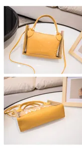 Detailweergave van gele transparante crossbodytas met binnentas op een witte tafel