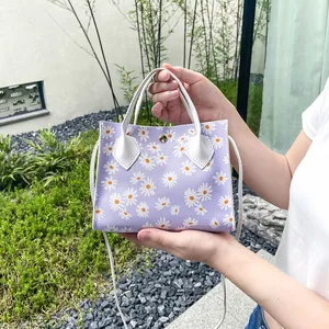 Stylish purple floral daisy handbag with white handles, perfect for women's fashion