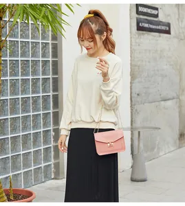 Detail view of a stylish pink small square chain crossbody bag with a metal lock closure