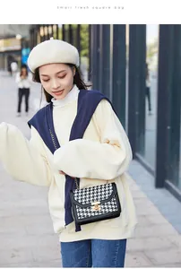 Stylish Asian model carrying a classic houndstooth crossbody bag with gold chain and buckle