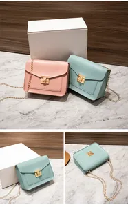 A detail view of textured chain crossbody bags in pink and mint green finishes.
