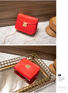Close-up detail of a red textured lizard pattern shoulder bag with gold chain and lock