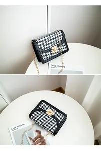 Close-up of black and white houndstooth crossbody bag with gold chain strap