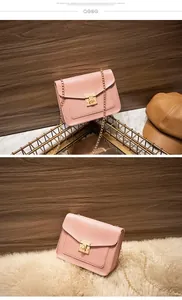 Detail view of pink lizard-texture crossbody chain bag with a gold metal clasp