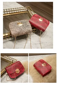 Dettaglio mini borsa zebra trendy con chiusura rotonda dorata e tracolla a catena