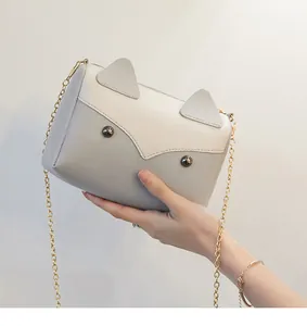 Dettaglio di una borsa a tracolla con orecchie di gatto nei colori grigio e bianco
