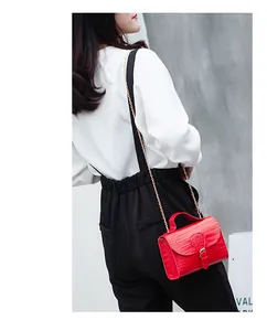 Detailed side view of a vibrant red stone-patterned small square bag with elegant gold chain strap