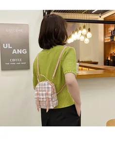 Fashionable mini plaid backpack shown in a lifestyle cafe setting on a model's back