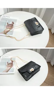 Detail view of fashion black crocodile pattern small square bag with golden chain strap