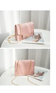 Detail views of a pink crocodile texture small square bag with gold chain and heart lock