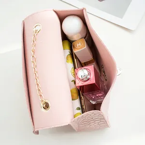 Pink stone pattern shoulder bag showing interior capacity with cosmetics