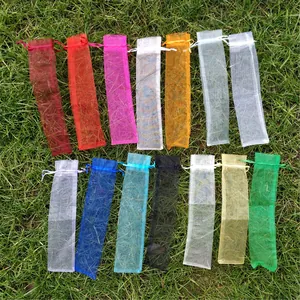 Selección de bolsas de organza de 23cm con cordón para abanicos sobre hierba verde