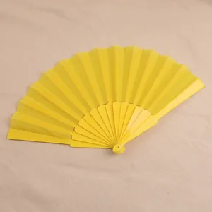Gedetailleerde weergave van een gele plastic vouwwaaier van 7 inch op beige doek