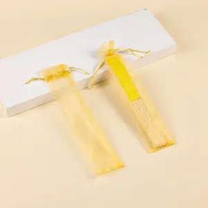 Detalle de bolsa amarilla de organza para abanicos con cierre de cordón ajustable